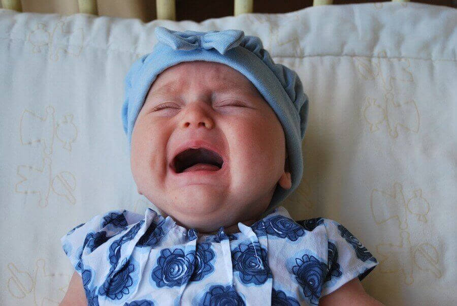 gråtande bebis i blå mössa