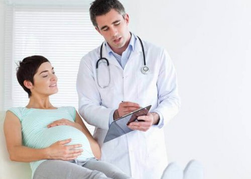 En läkare pratar med en gravid kvinna.