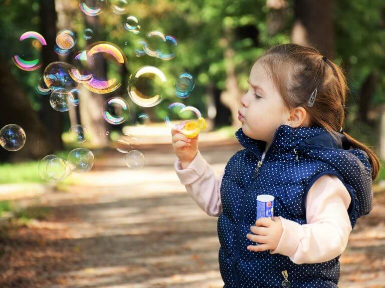 Flicka som blåser bubblor.