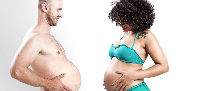 man och gravid kvinna jämför magar