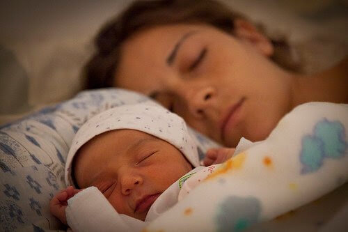kvinna och spädbarn sover