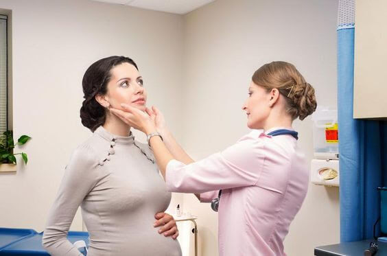 läkare undersöker gravid kvinna