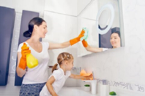mamma och barn städar i badrummet