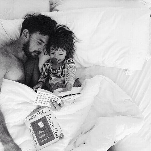 pappa läser bok för barn i säng