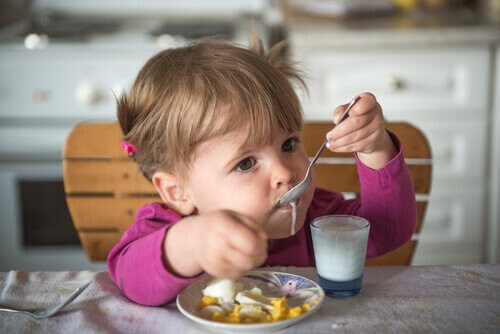 baby äter yoghurt och frukt