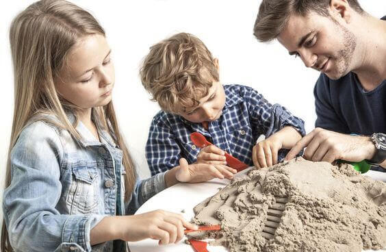 Familj leker med magisk sand