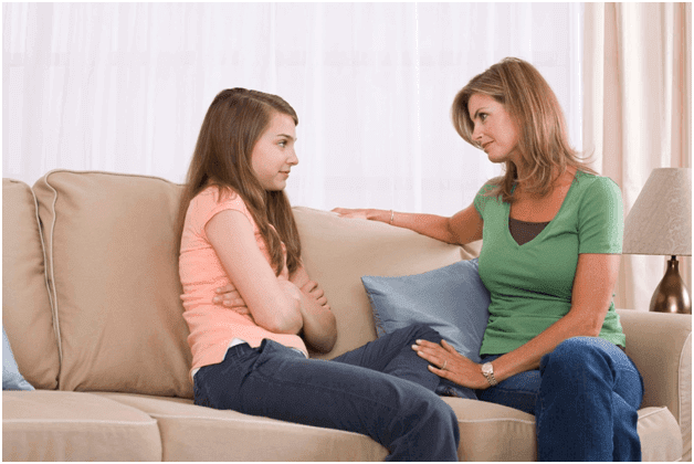 mamma och tonårsdotter på soffa