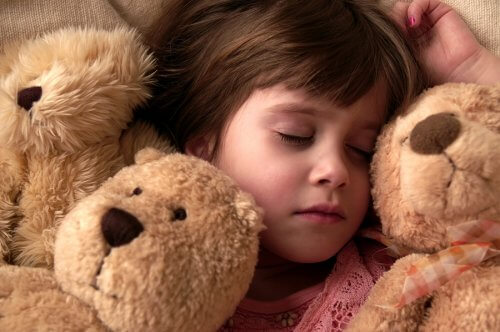 Barn som sover med nalle.