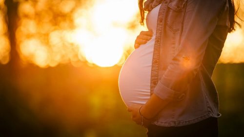 Gravid kvinna som håller om sin mage.