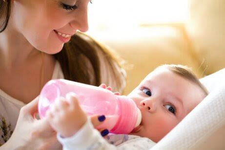 Hål i tänderna av nappflaskan: baby med nappflaska