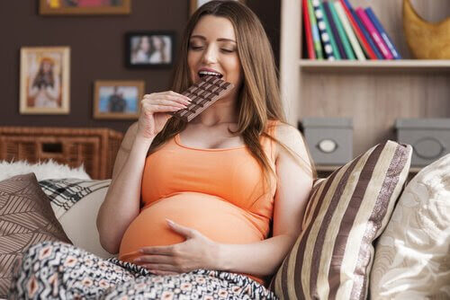 Gravid kvinna äter choklad