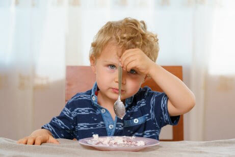 pojke håller skeden i vänster hand