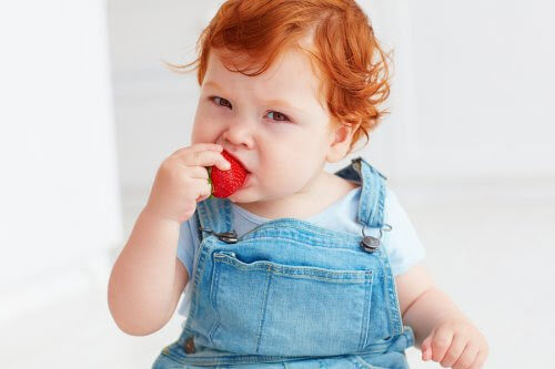 baby äter jordgubbe