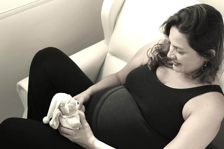 gravid kvinna håller gosedjur