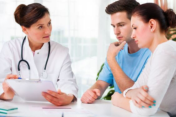 läkare talar med man och kvinna om cervixinsufficiens