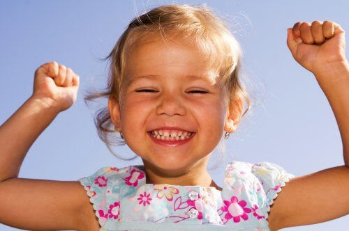 Optimistiska barn: glad flicka gör segergest