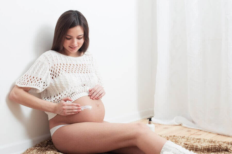 gravid kvinna smörjer in magen