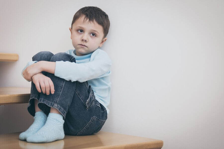nedstämd pojke sitter på golvet