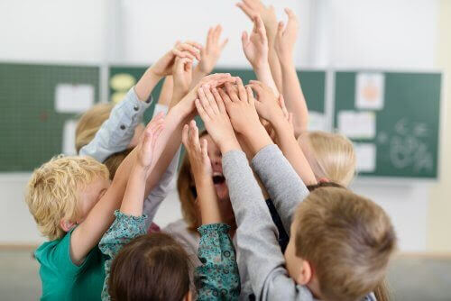 Barn med händerna uppe runt en glad lärare