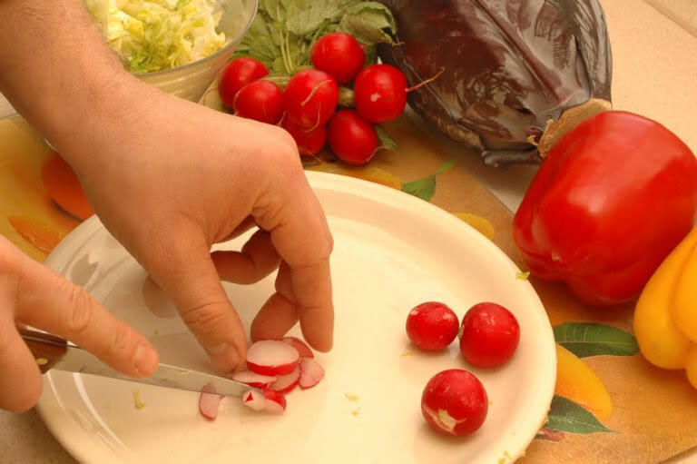 händer skär upp rädisor