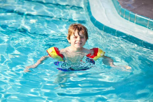 pojke med flytringar i pool