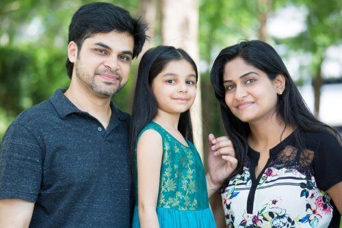 Familjefoto med ensambarn i mitten.