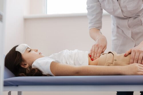 Flicka med appendicit blir undersökt av en doktor.