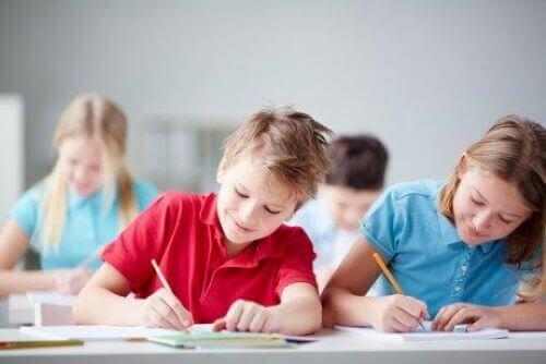 Barn sitter i skolbänken och skriver.