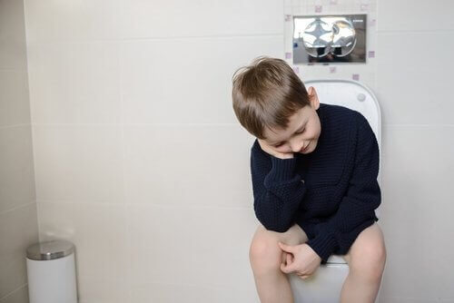 Ett barn sitter på toaletten och försöker bajsa.