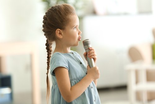 Barn sjunger i mikrofon.