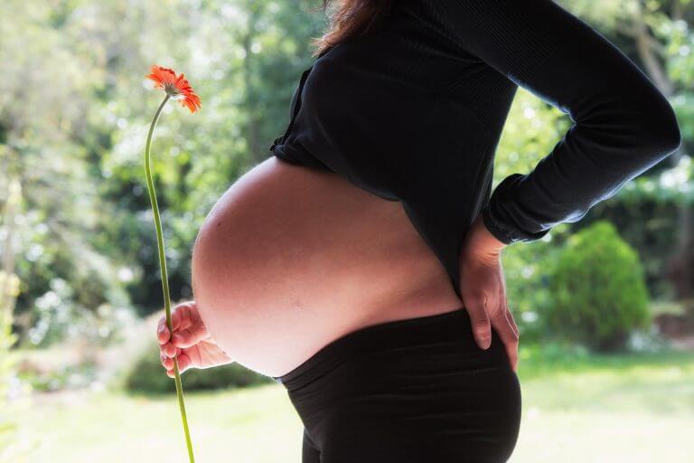 Gravid kvinna med blomma.