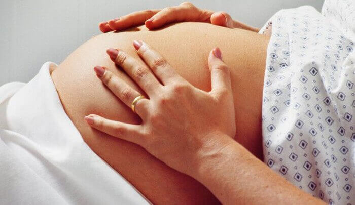 Kvinna som håller om sin mage.