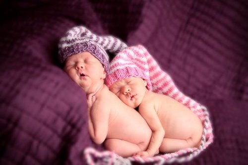 Identiska tvillingar sover bredvid varandra.
