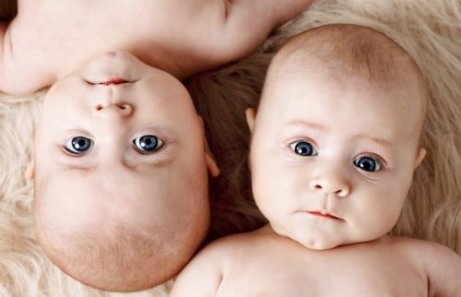 Tvillingbebisar med blå ögon.
