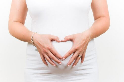 gravid kvinna håller sig för magen