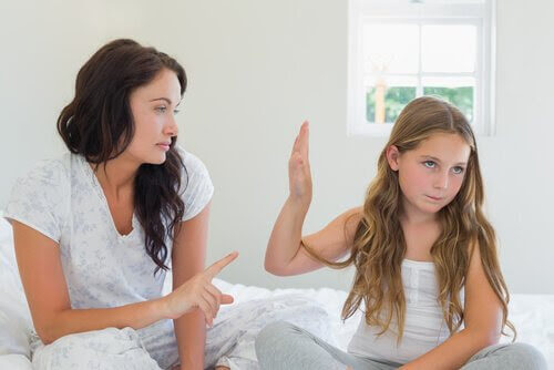 flicka håller upp handflata mot mamma som pekar