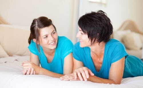 menstruationscykel: mamma och dotter pratar på säng