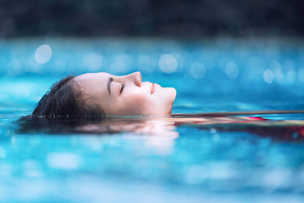 Hydroterapi för gravida: avslappnad kvinna flyter i pool