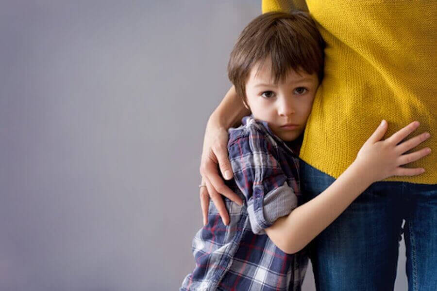 Blyghet under barndomen: blygt barn håller om sin mamma