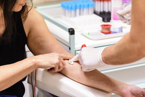 sjuksköterska tar blodprov på arm