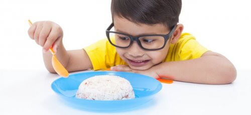 pojke tittar på en tallrik med ris