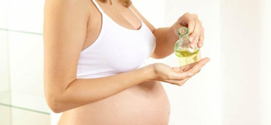undvika en episiotomi: gravid kvinna häller upp olja