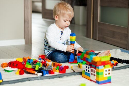 En pojke leker med lego.