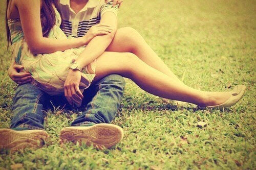 tonårsflicka sitter i knäet på tonårspojke