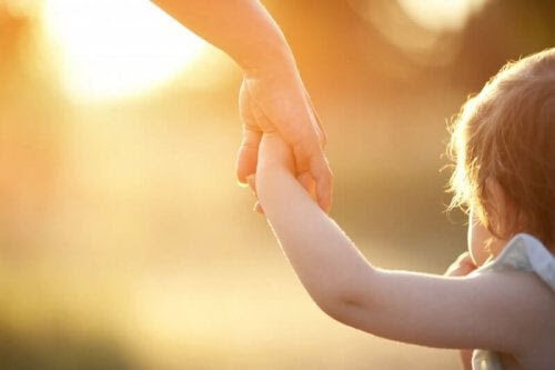 vuxen håller barns hand