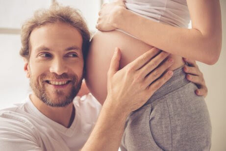 man med örat mot gravid mage