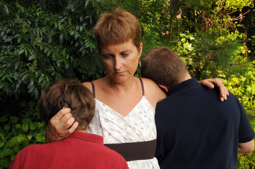 mamma håller om två barn