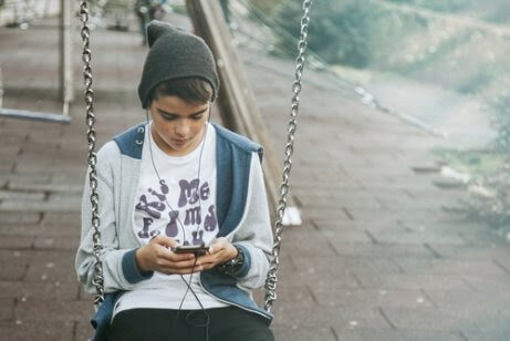 tonåring på gunga med mobil