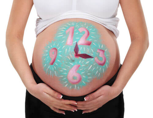 gravid kvinna med klocka målad på magen