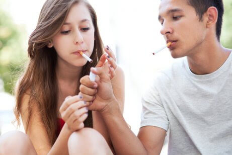 rökning bland tonåringar: pojke med cigarett tänder en flickas cigarett
